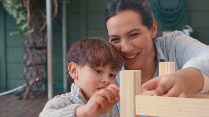 一名年轻女子和她可爱的儿子在家里做一个木制项目的4k视频片段