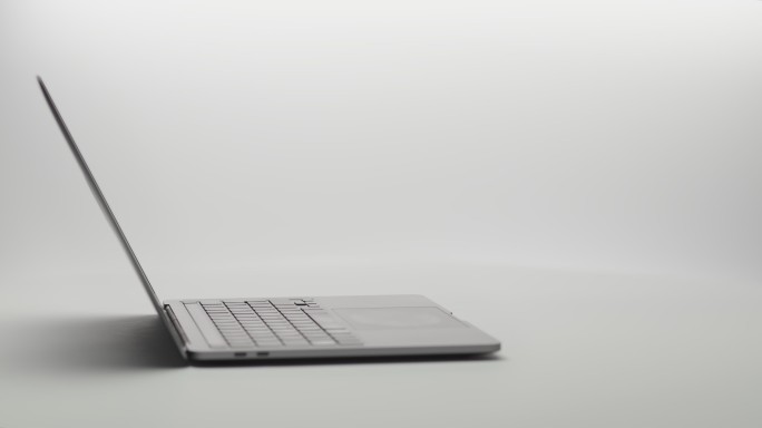 现代笔记本电脑在白色背景下绕轴旋转。笔记本电脑将显示器展开到摄像头中。笔记本电脑显示器具有绿色屏幕、