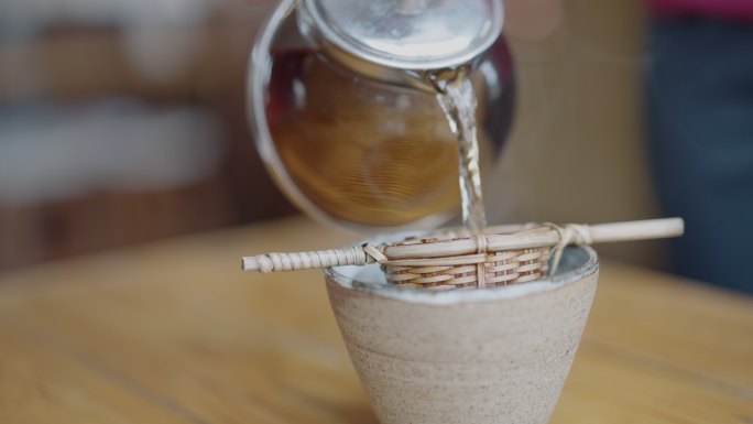 用竹滤器把茶倒进杯子里