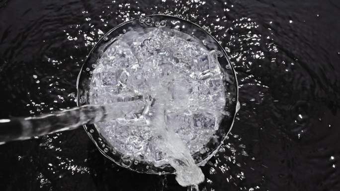 以慢动作将水倒入冰杯中。
