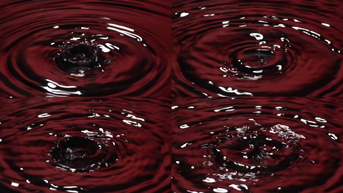 慢动作：许多水滴滴入红色水中。