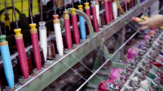 在织布机上纺彩色线的线轴轮。