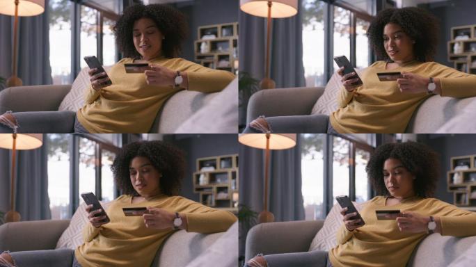 一名年轻女子在家沙发上使用智能手机和信用卡的4k视频片段
