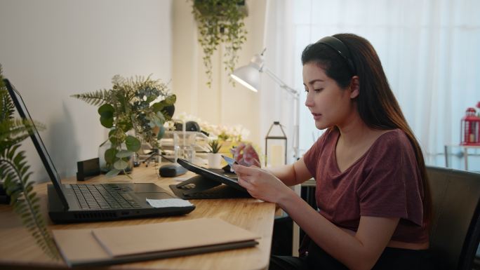 怀孕的网店老板在家里使用数字平板电脑。远程工作、怀孕、自由职业