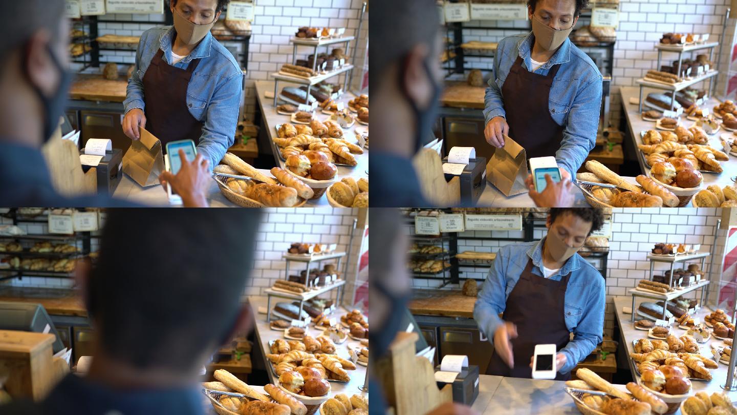 在面包店用手机付账的男人