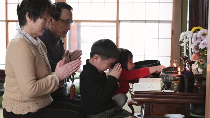 日本多代家庭在家庭佛坛前祈祷