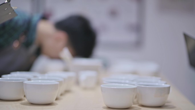3名专业亚裔中国男咖啡师品酒师品酒后在剪贴板上记录咖啡杯