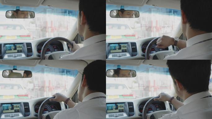 一名亚洲男子早上开车上班时看手表，上班迟到了。交通拥挤