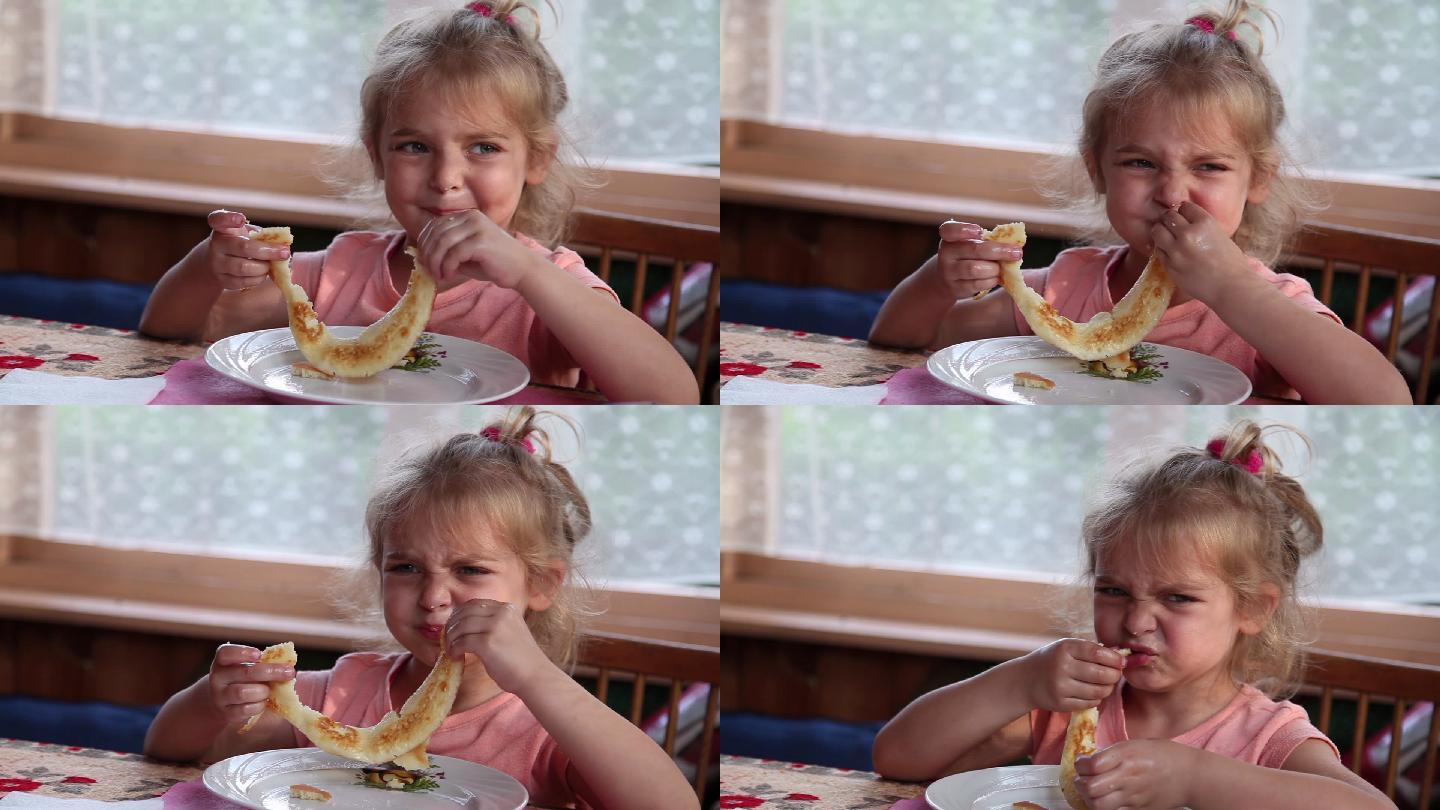 小女孩吃早餐时厌恶地皱着眉头
