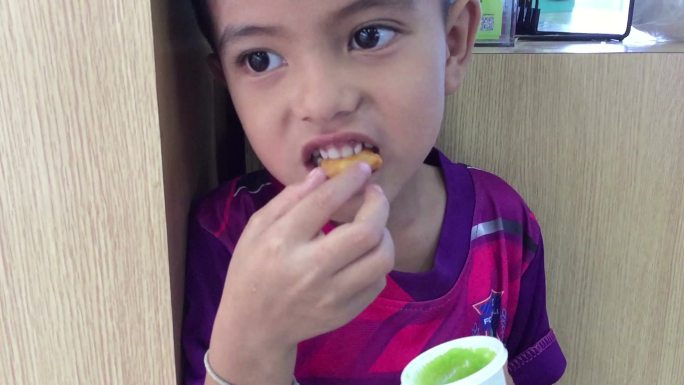 小男孩吃中国面团和潘丹奶油冻