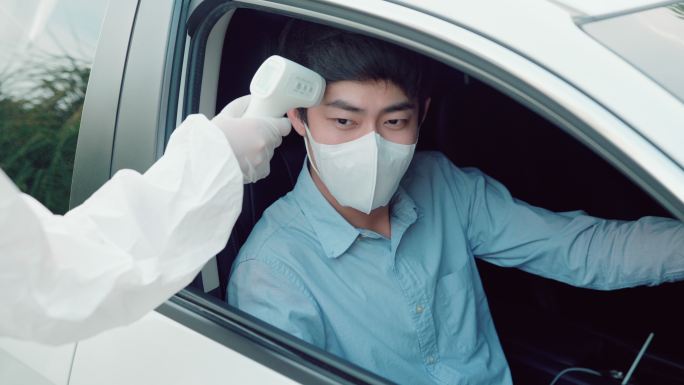 一名年轻男子驾车前往鼻拭子检测是否可能感染冠状病毒。