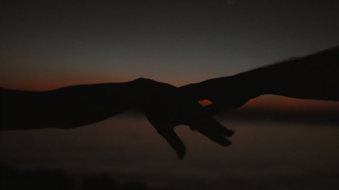 手在夕阳的天空中翩翩起舞。海景浪漫