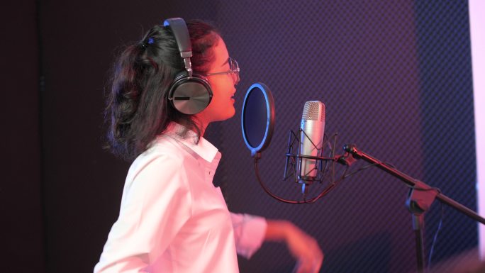 亚洲女孩在录音室唱歌
