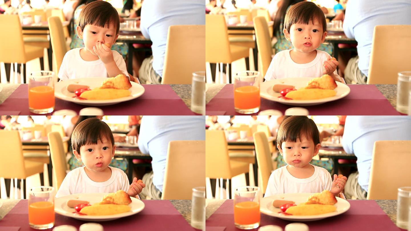 HD：蹒跚学步的男孩独自吃早餐。