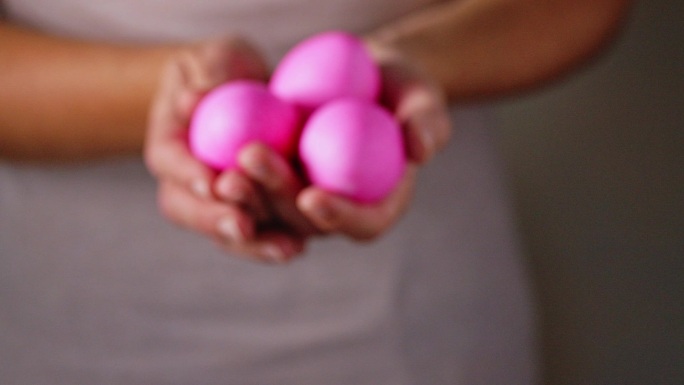 一名手持粉红色复活节彩蛋的妇女的特写镜头