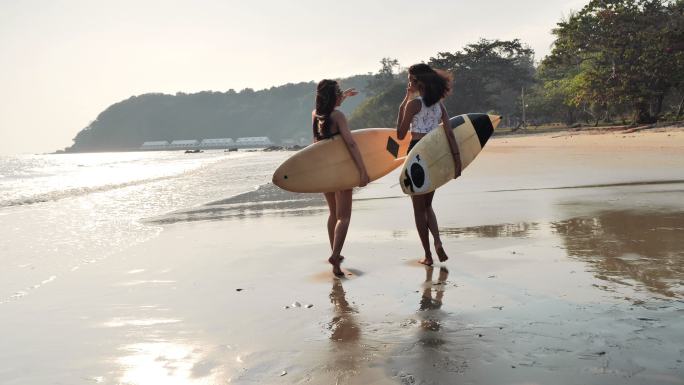 在海滩上，两个穿着比基尼、穿着白色冲浪板的美丽年轻女子在冲浪。体育电影