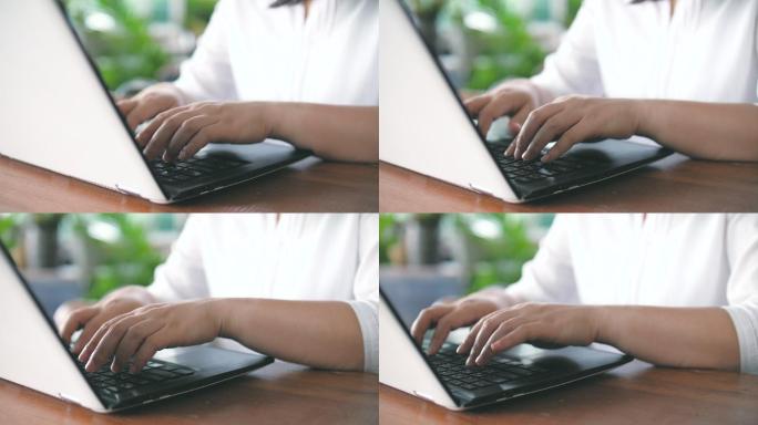 女性用手在笔记本电脑键盘上打字