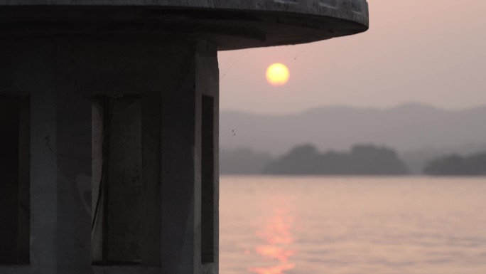 夕阳下西湖上的水泥灯塔