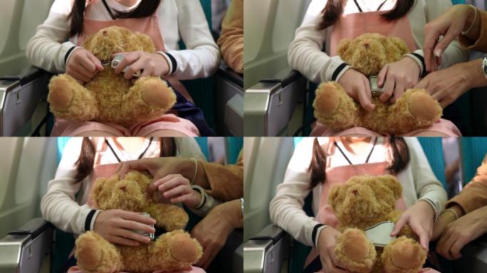 安全概念一个女孩在飞行中，在飞机座位上给她的泰迪熊系上安全带。