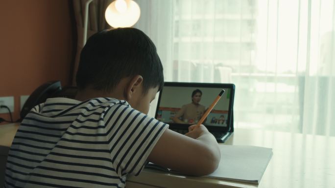 亚洲男孩正在家里参加在线课程。