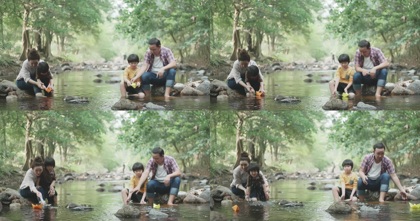 两个儿子在河边玩纸船，亚洲家庭快乐
