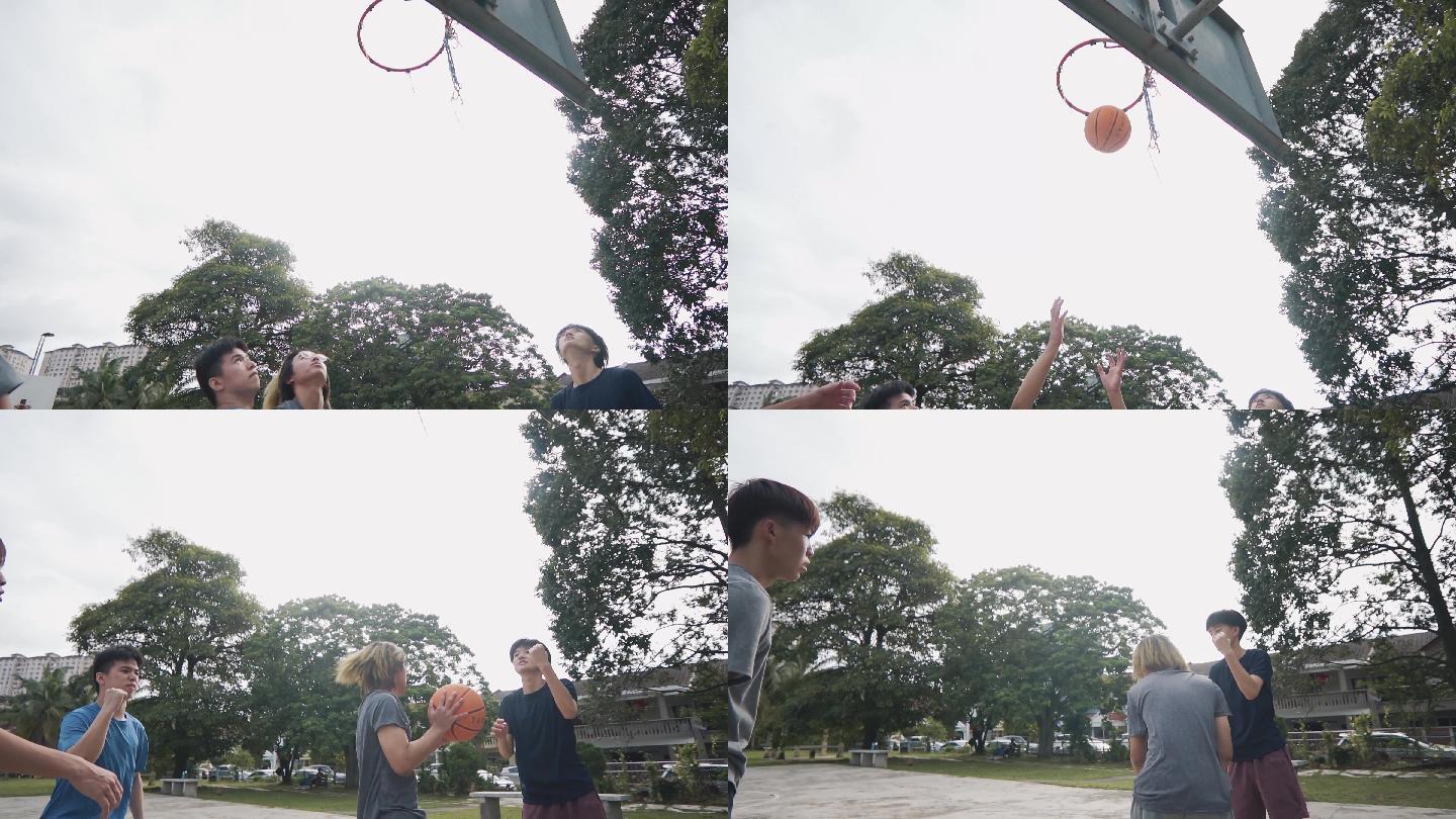 慢动作背光Z代亚裔中国少年在周末早上与朋友练习篮球比赛时挑战球员并投篮