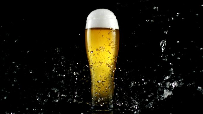 水珠砸在装满啤酒的玻璃杯上。新鲜度隐喻