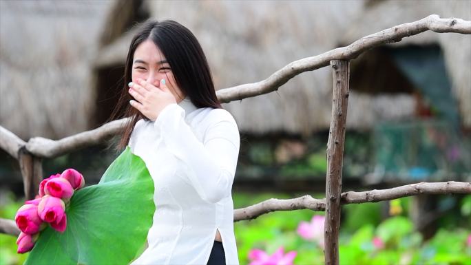 越南荷花田上越南妇女抱着荷花的慢镜头