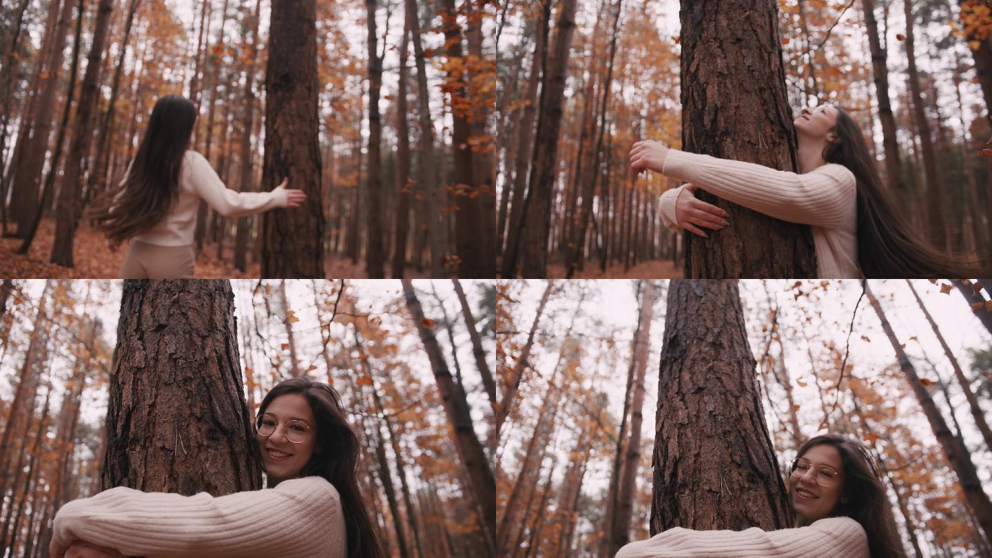 快乐的年轻女子在公园里拥抱树