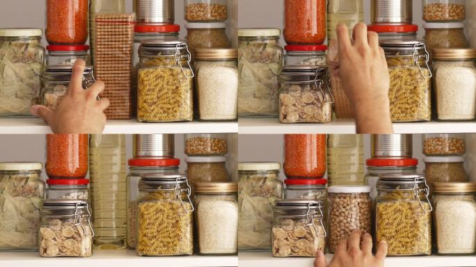 一名男子从食品储藏室的货架上取下或放置装满豆类的玻璃罐