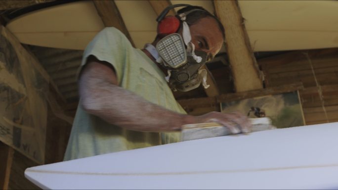 一名男子冲浪板造型师在工作室努力工作的4k视频片段