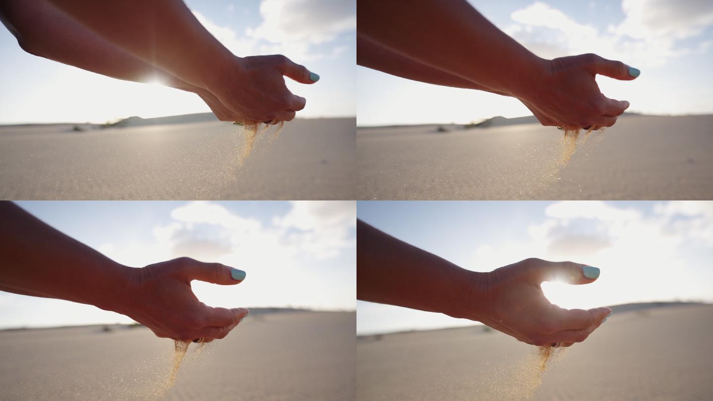 一个女人用沙子捧着双手的详细照片