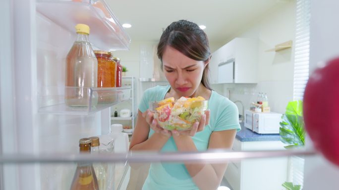 女士打开冰箱食物变质食物过期食物变味