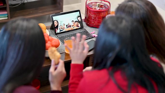 快乐的亚洲家庭在家里通过数字平板电脑上的视频通话在线迎接中国新年，并与亲戚团聚