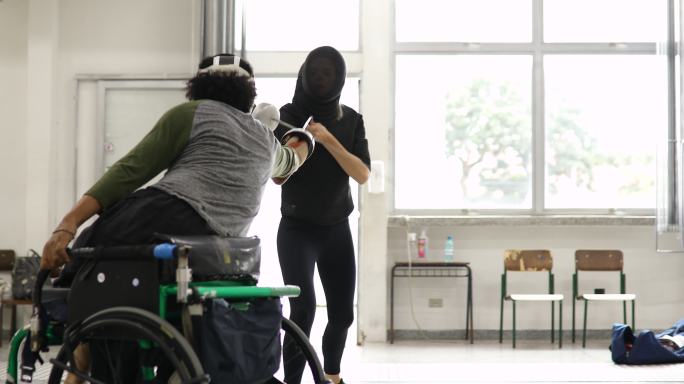 男子轮椅击剑运动员与教练一起训练