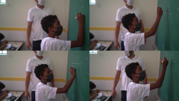 戴口罩的学生在黑板上做数学