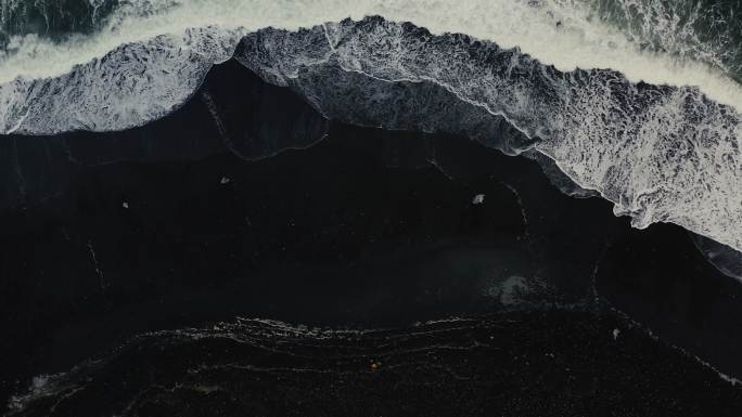 冰岛黑沙滩上有冰山的男女鸟瞰图