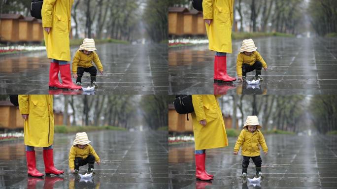 孩子和妈妈在水坑里玩纸船