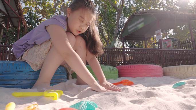 小女孩在沙箱里玩沙子