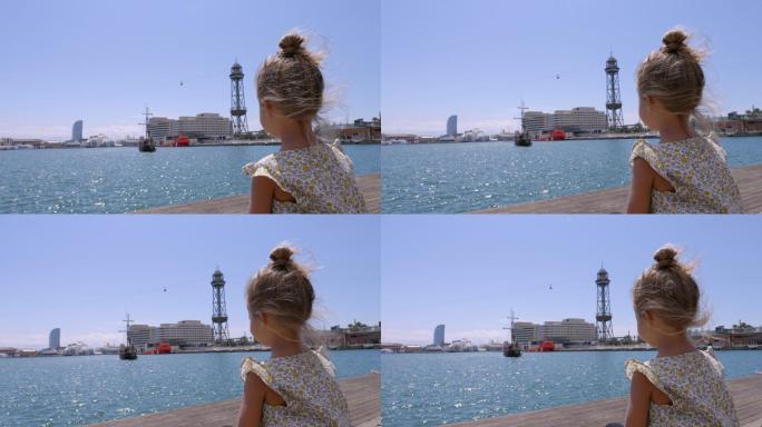 巴塞罗那港的少女小女孩坐海边背影