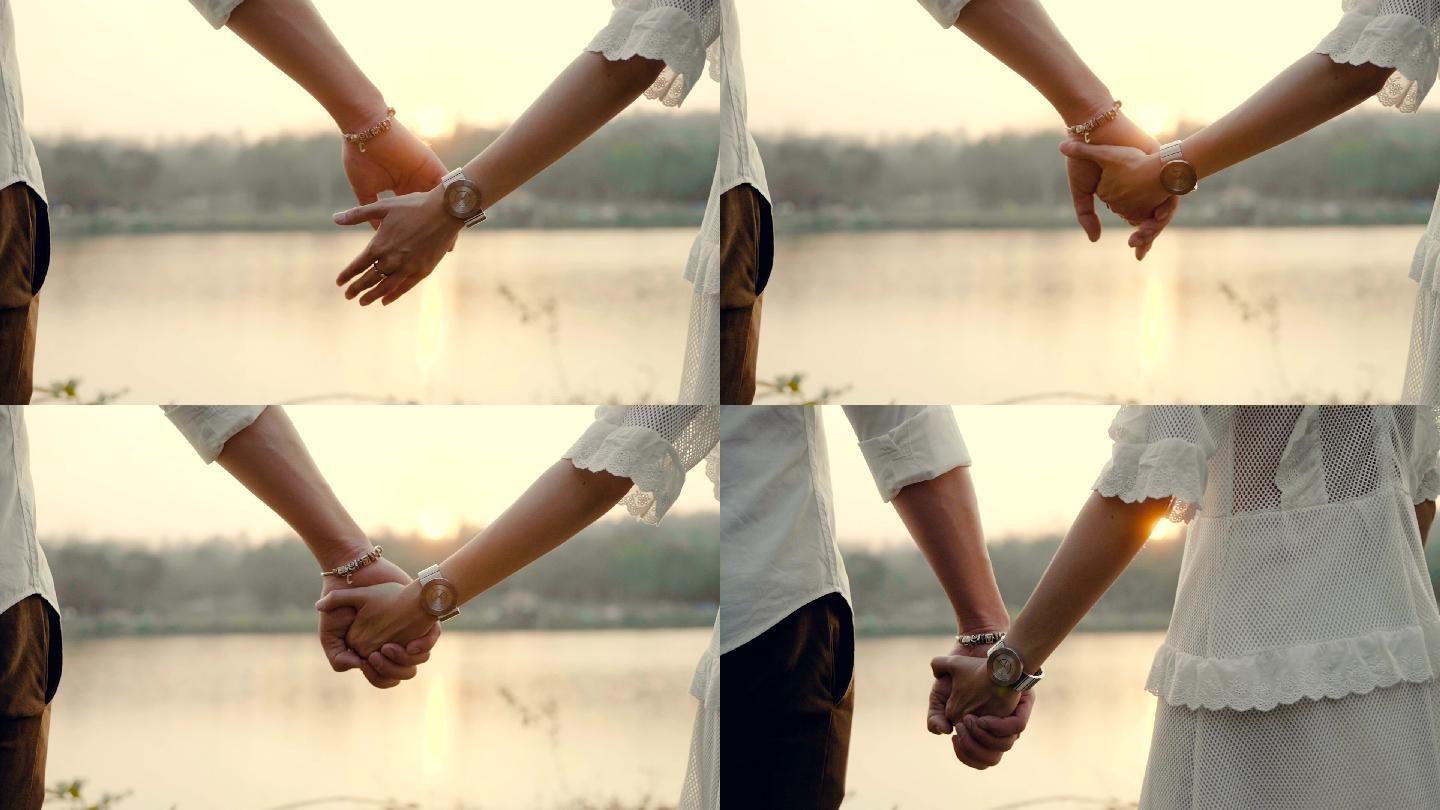 日落时分，一对情侣手牵着手走着。