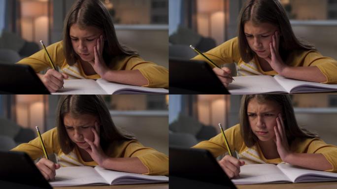 一个年轻女孩独自坐在家里做作业时感到沮丧的4k视频片段