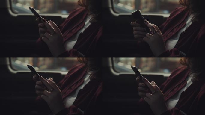 年轻女子在车内使用智能手机。