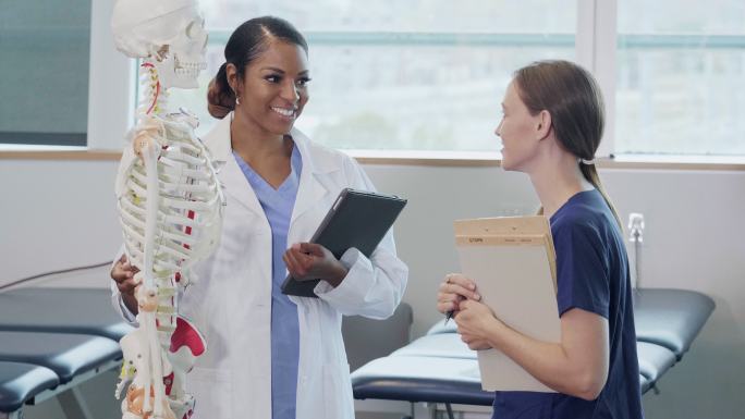护理学院教授与女生讨论骨骼系统