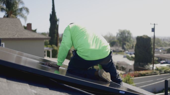 加利福尼亚州住宅屋顶安装太阳能电池板的工人团队