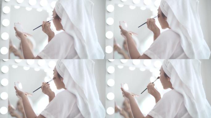 女性在脸颊上使用化妆刷
