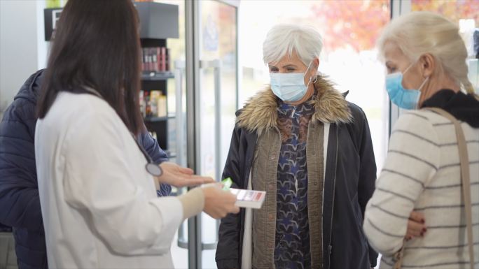 女药剂师向老年人讲解如何使用药丸管理器