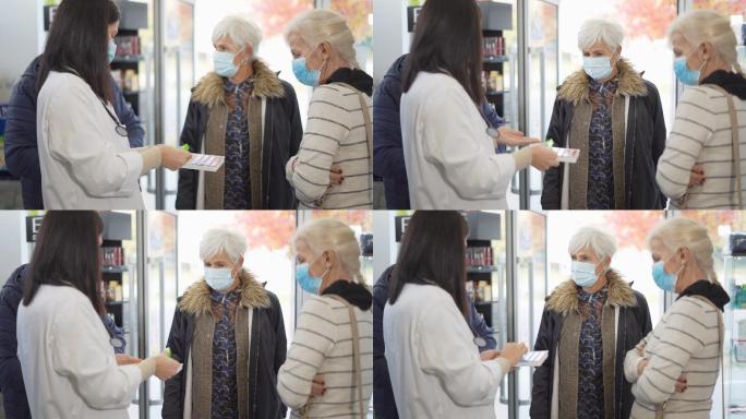 女药剂师向老年人讲解如何使用药丸管理器