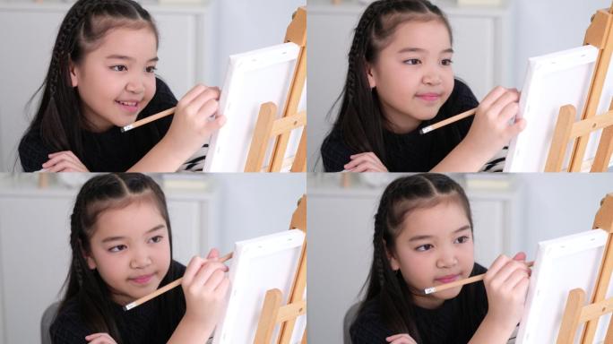 亚洲可爱女孩在帆布画框上素描
