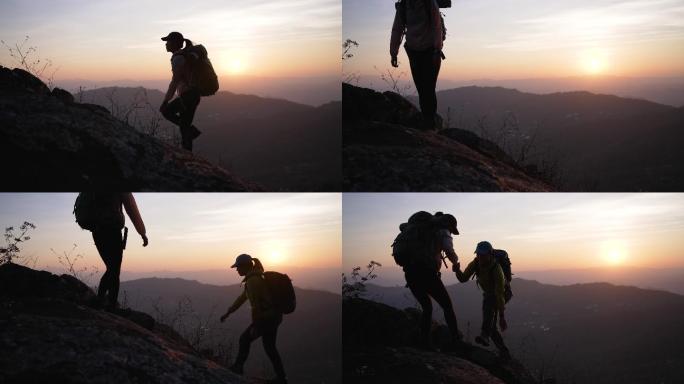 两个徒步旅行者在登山小道上帮助登上山顶